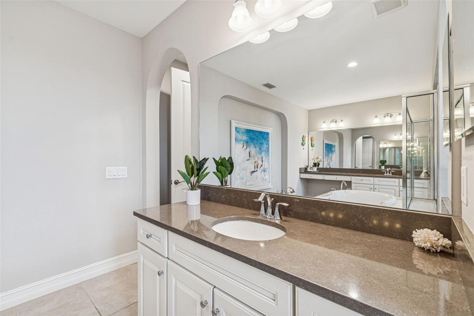 Spa-inspired primary en suite featuring a soaking tub, oversized shower, dual vanities, and generous storage