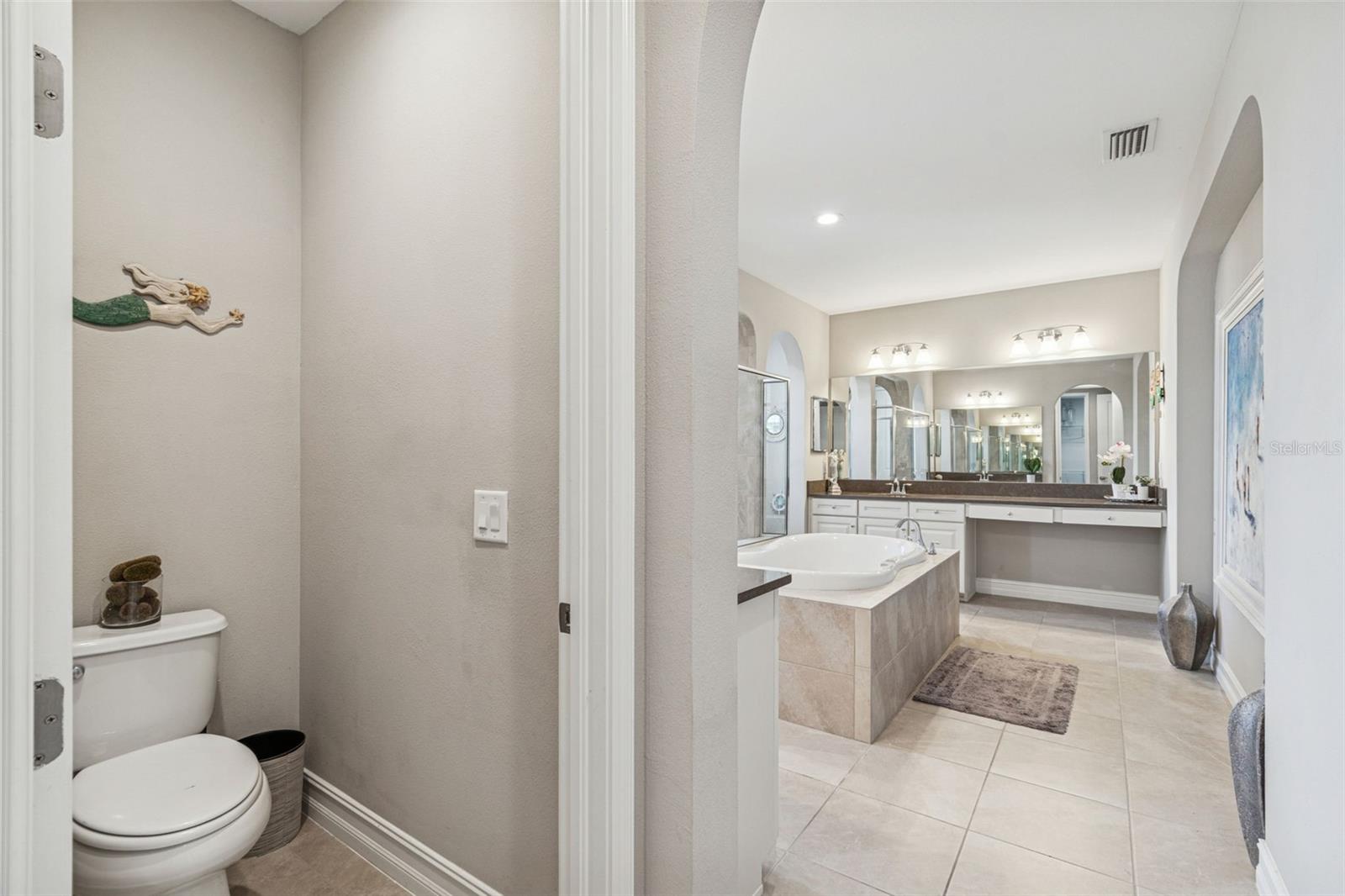 Spa-inspired primary en suite featuring a soaking tub, oversized shower, dual vanities, and generous storage
