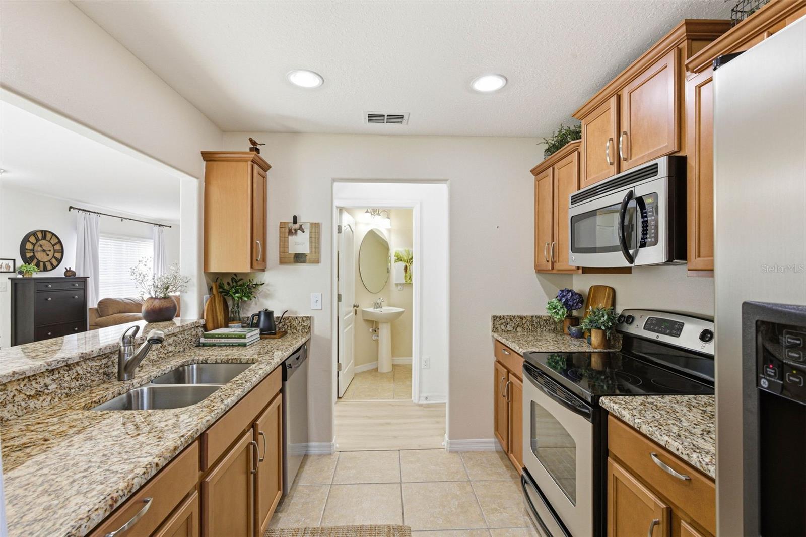 Kitchen view towards hall with closet and half bath