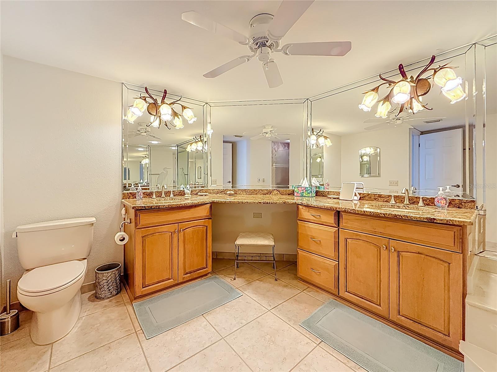 Double vanities in the primary bathroom with enough space for a make-up area.