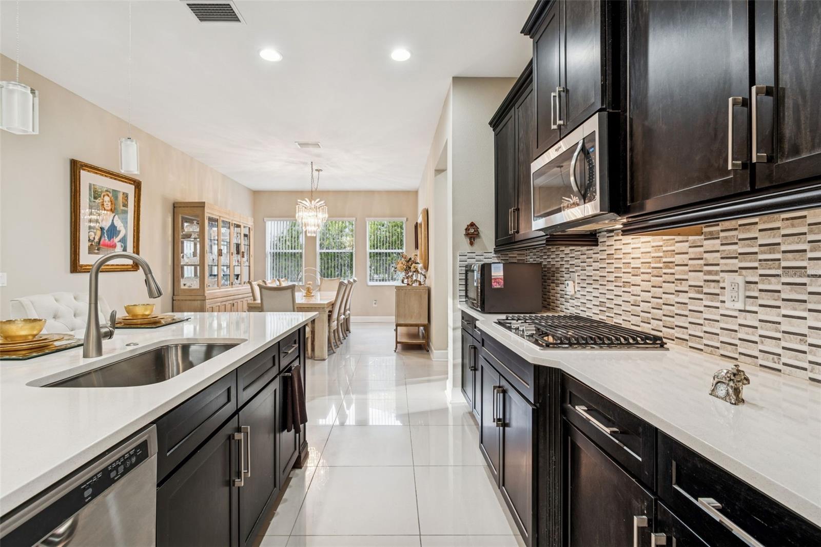Well-appointed kitchen with quartz countertops, stainless steel appliances, and oversized island with view of dining area