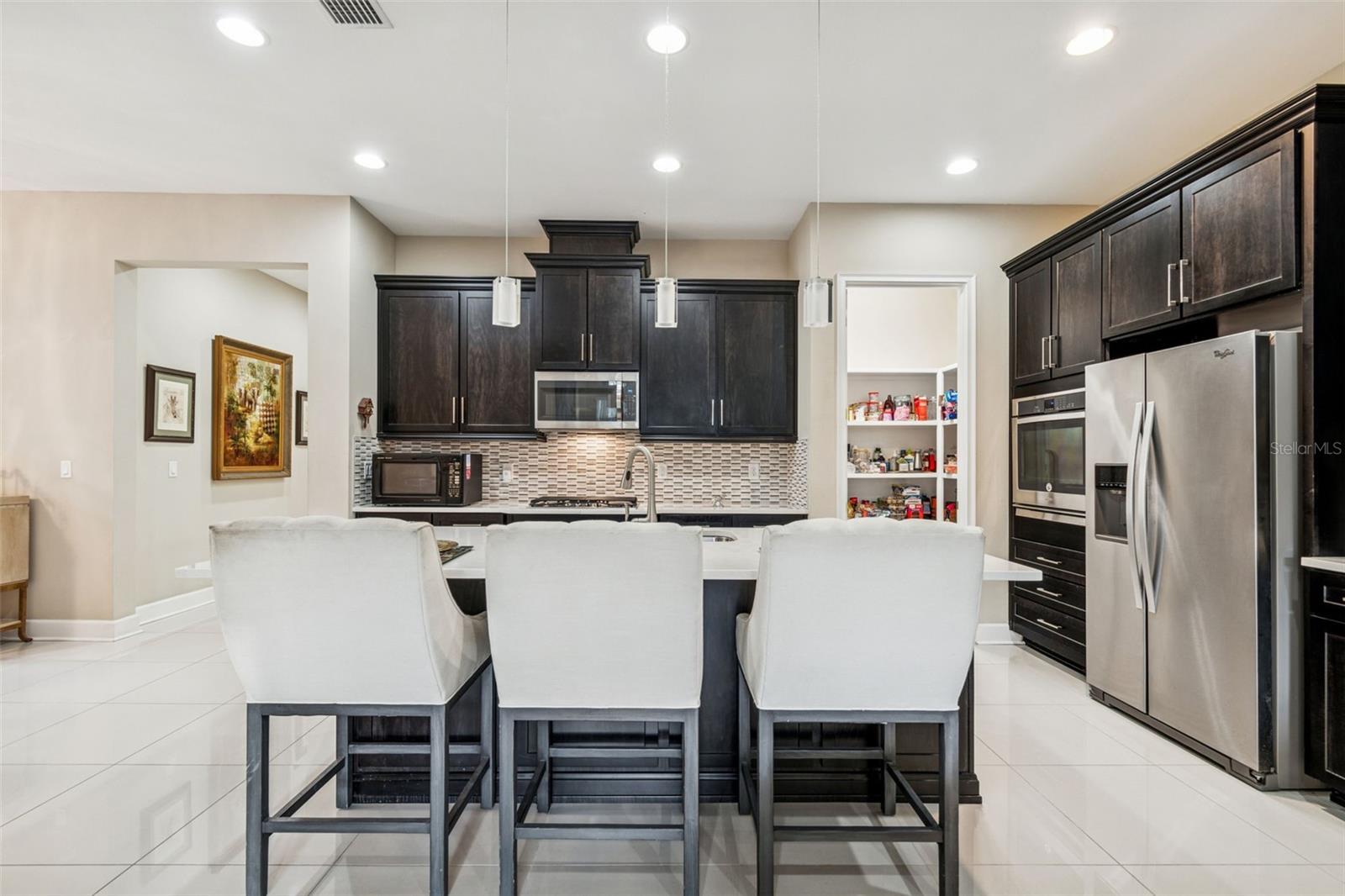 Well-appointed kitchen with quartz countertops, stainless steel appliances, and oversized island