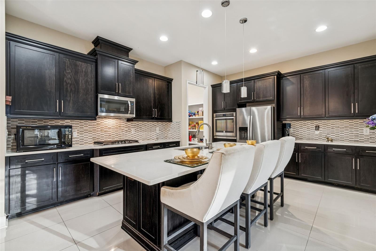Well-appointed kitchen with quartz countertops, stainless steel appliances, and oversized island