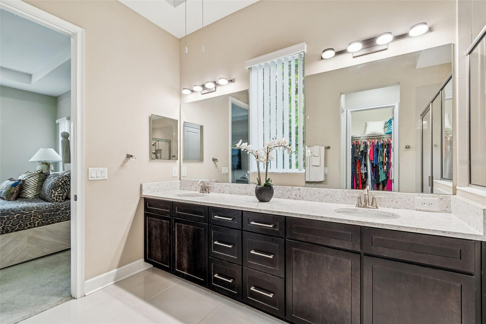 Primary en-suite bath with dual sinks, generous counter space, an oversized walk-in shower and plentiful storage.