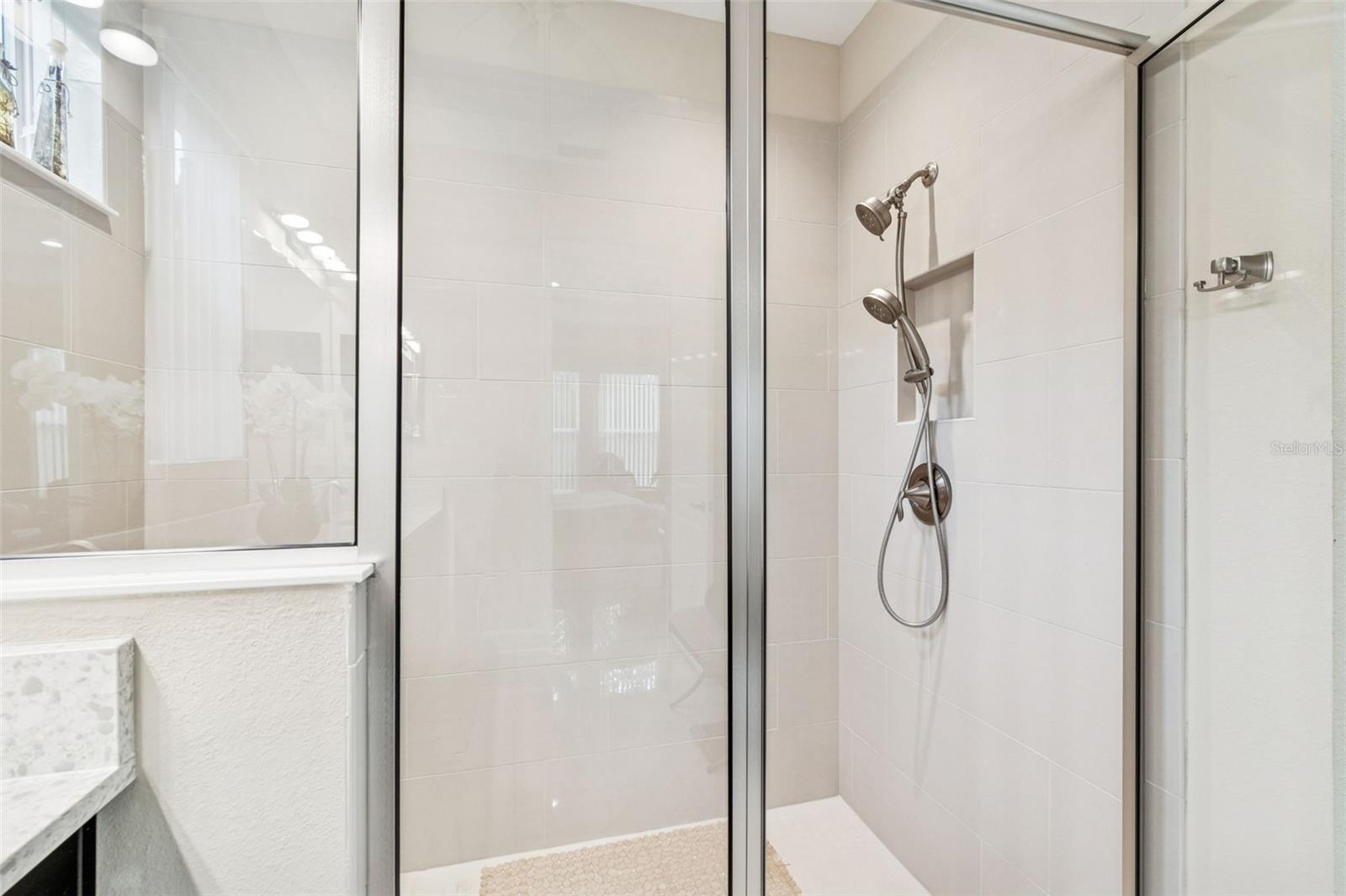 Primary bath featuring an oversized walk-in shower with glass enclosure and tile surround
