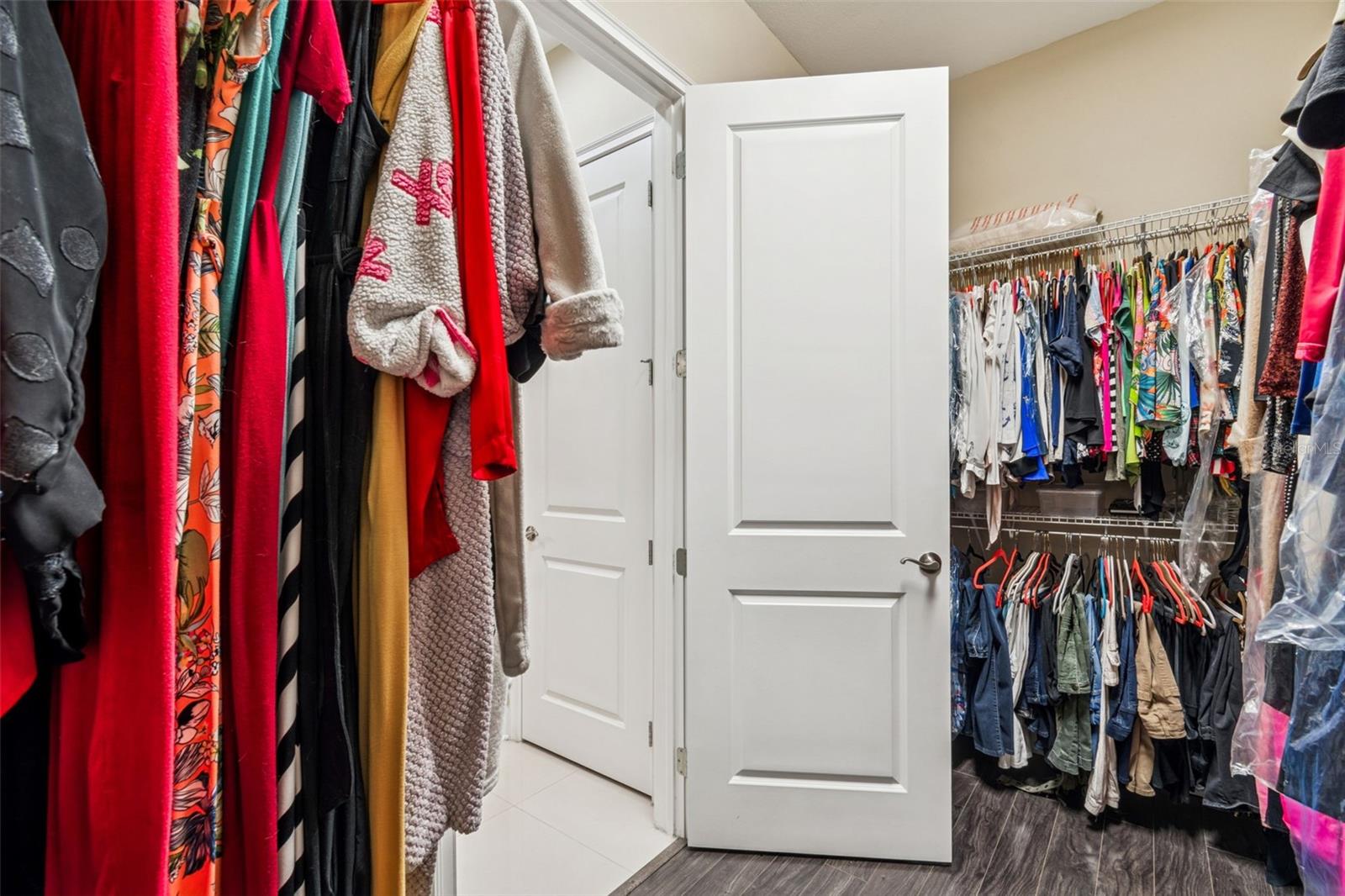 Primary ensuite with oversized walk-in closet and view of linen closet