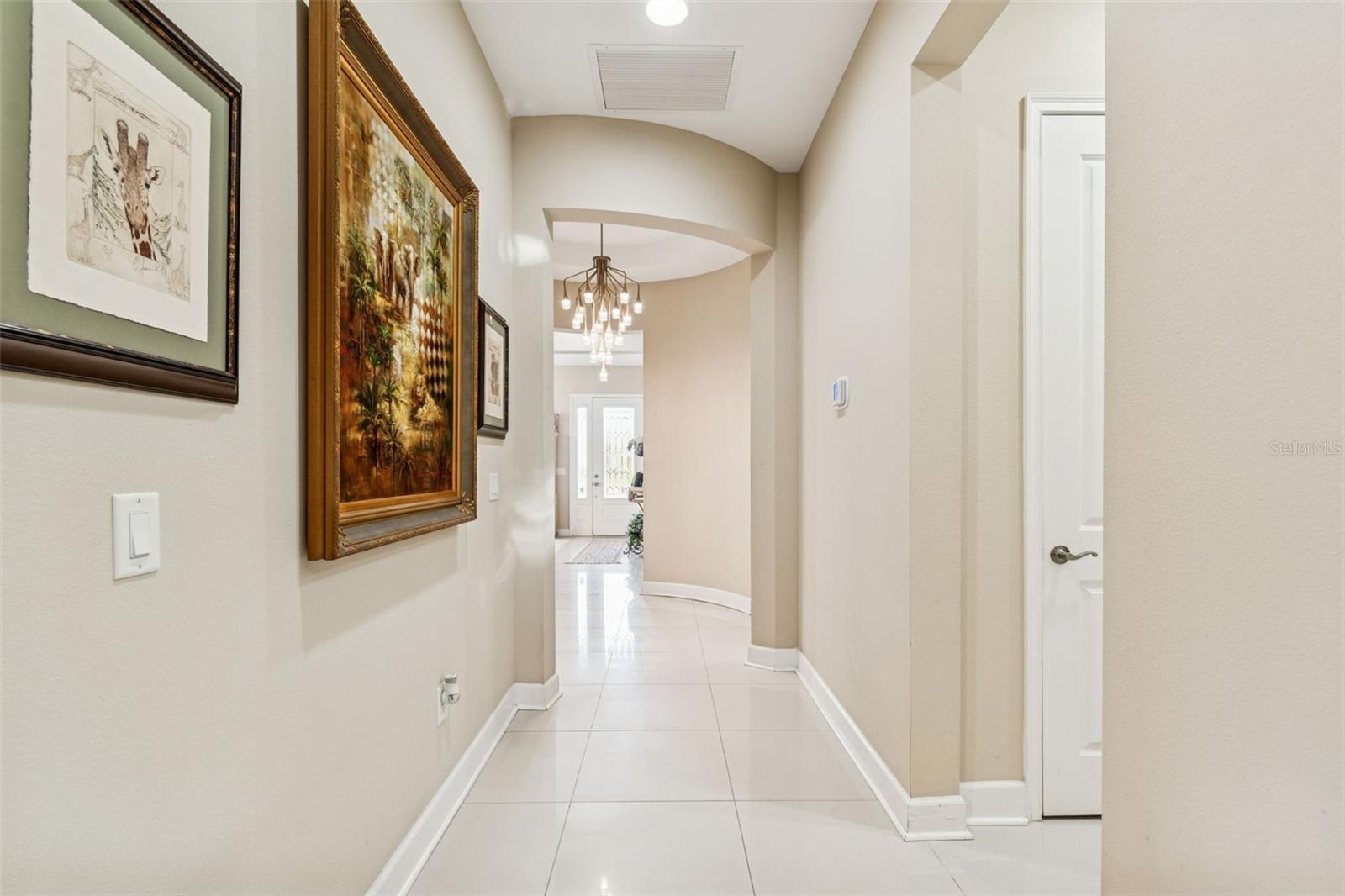 Graceful arched hallway with designer lighting connecting the main living areas