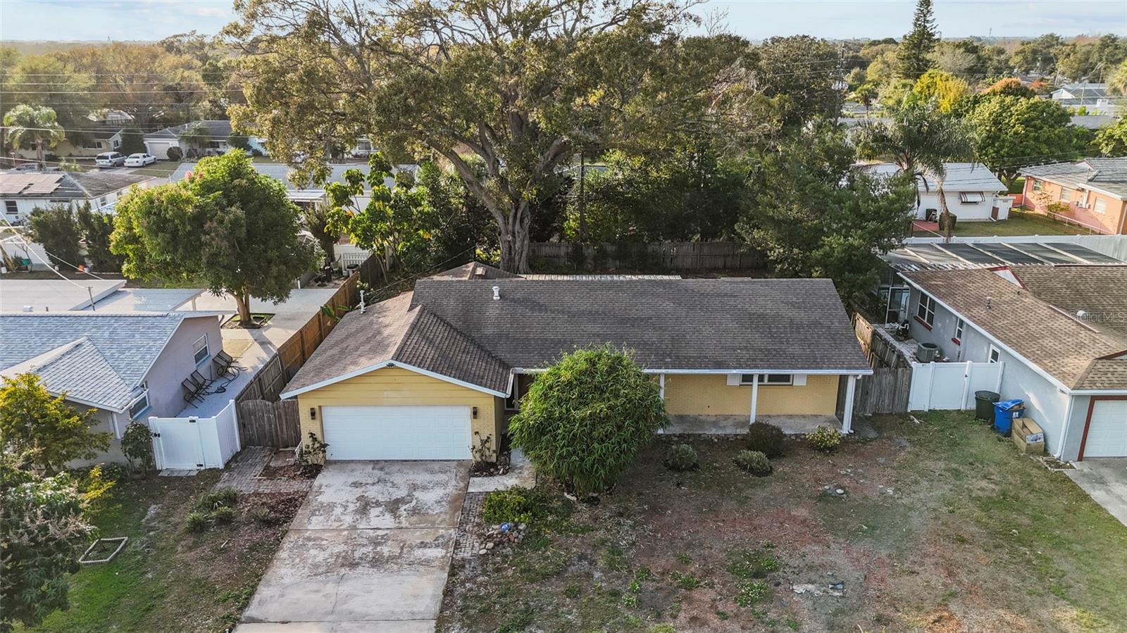 Overhead view showing the home’s roof, driveway, and large lot.