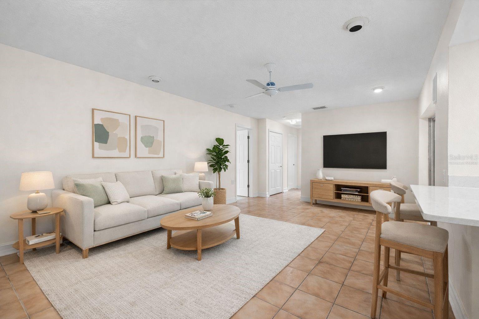 Virtually staged family room with sliders to the pool area and access to kitchen