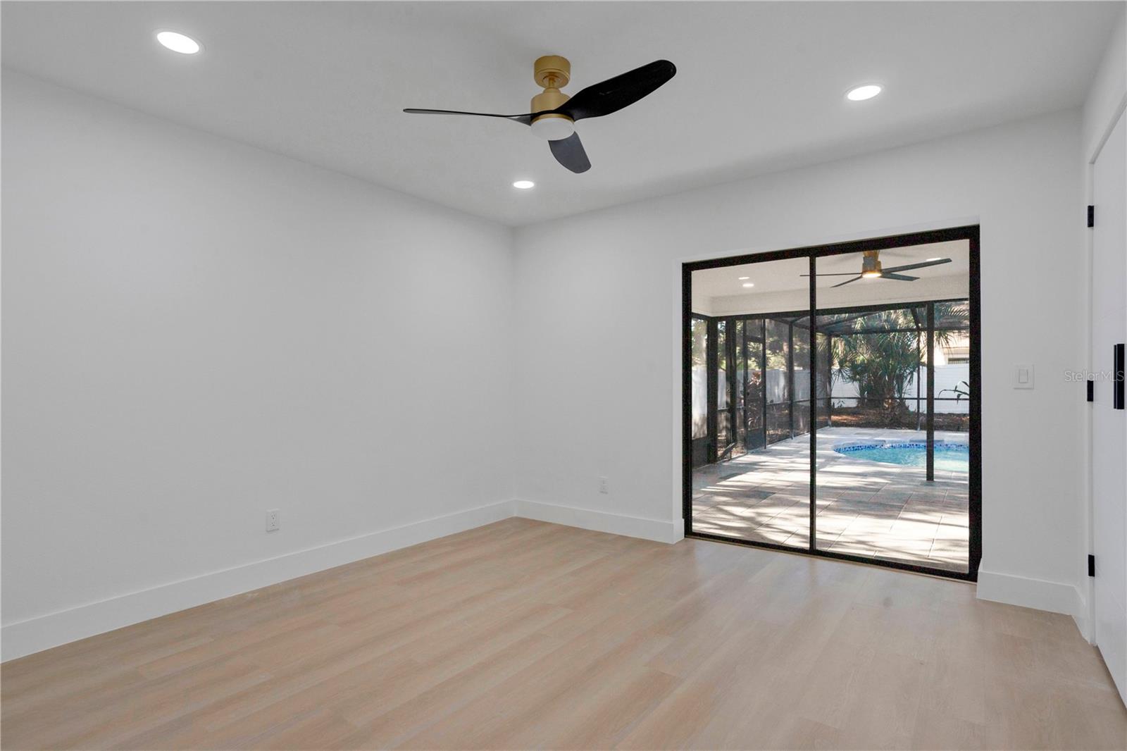 Bedroom 2 with sliders to the screened in pool area