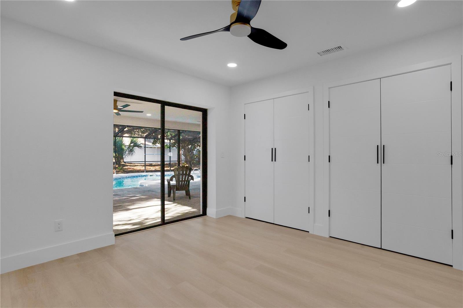 Bedroom 2 with sliders to the screened in pool area