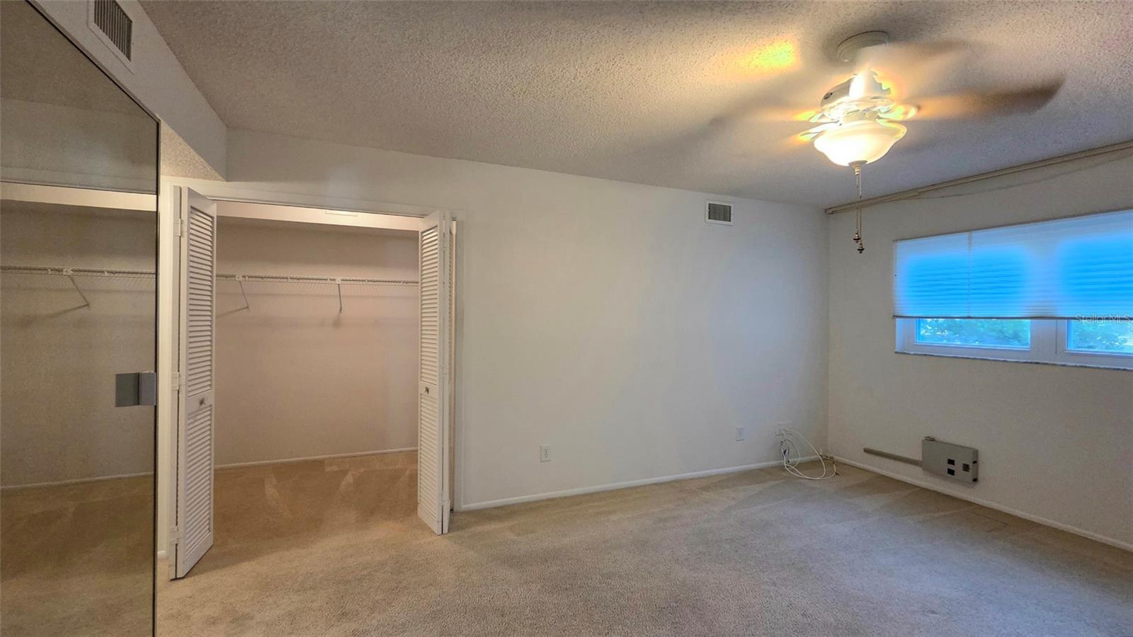 Primary Bedroom Shows part of lg walk-in closet