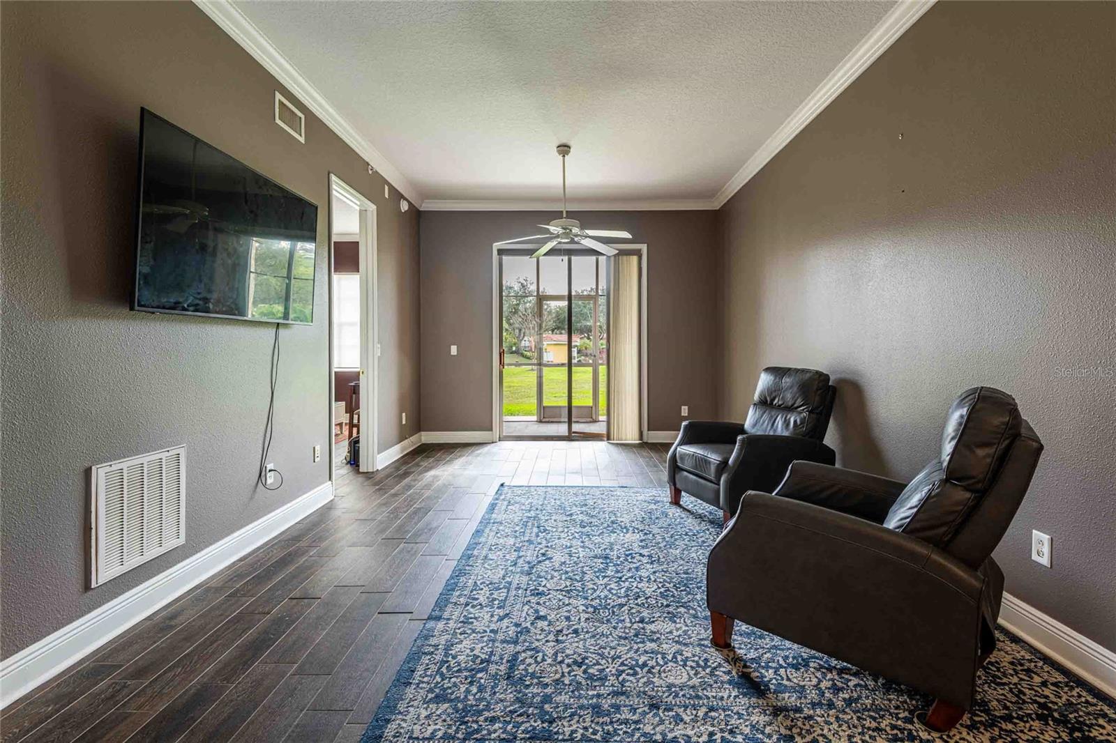 Living area showing sliding doors to screen lanai.  Room is wider than appears in picture