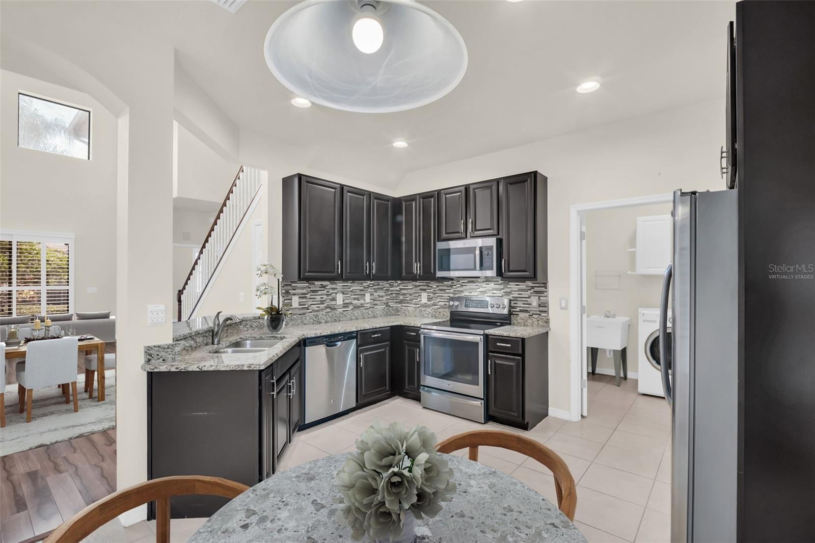 Updated kitchen with granite countertops, sleek stainless appliances, & recessed lighting~ VIRTUALLY STAGED