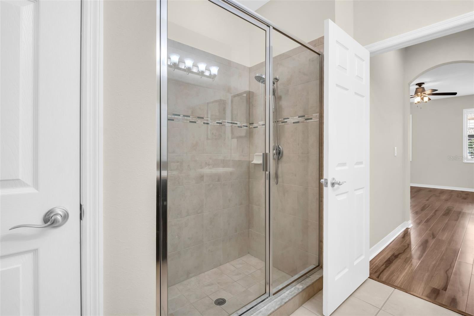 Linen closet and large walk-in shower with glass enclosure~
