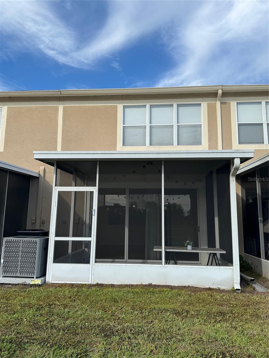 Rear view of townhome with covered screen porch!