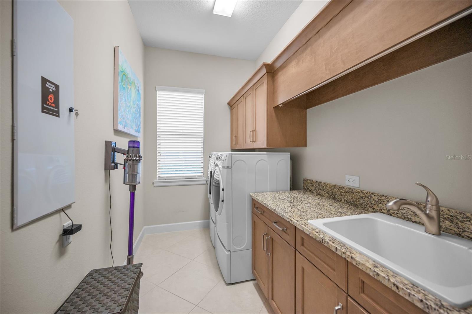 Large laundry room with granite countertop and sink