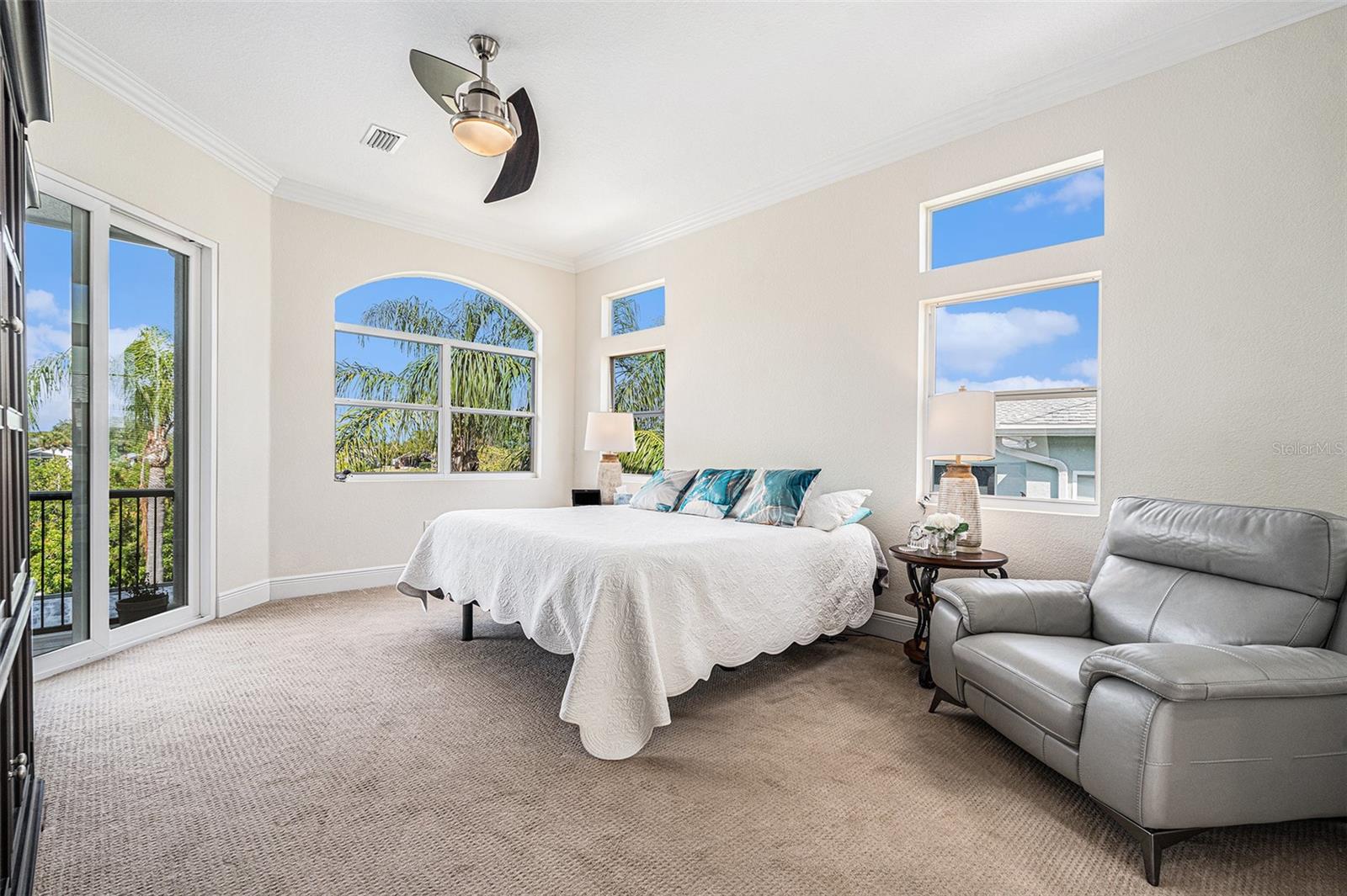 primary bedroom with sliders to screened in patio