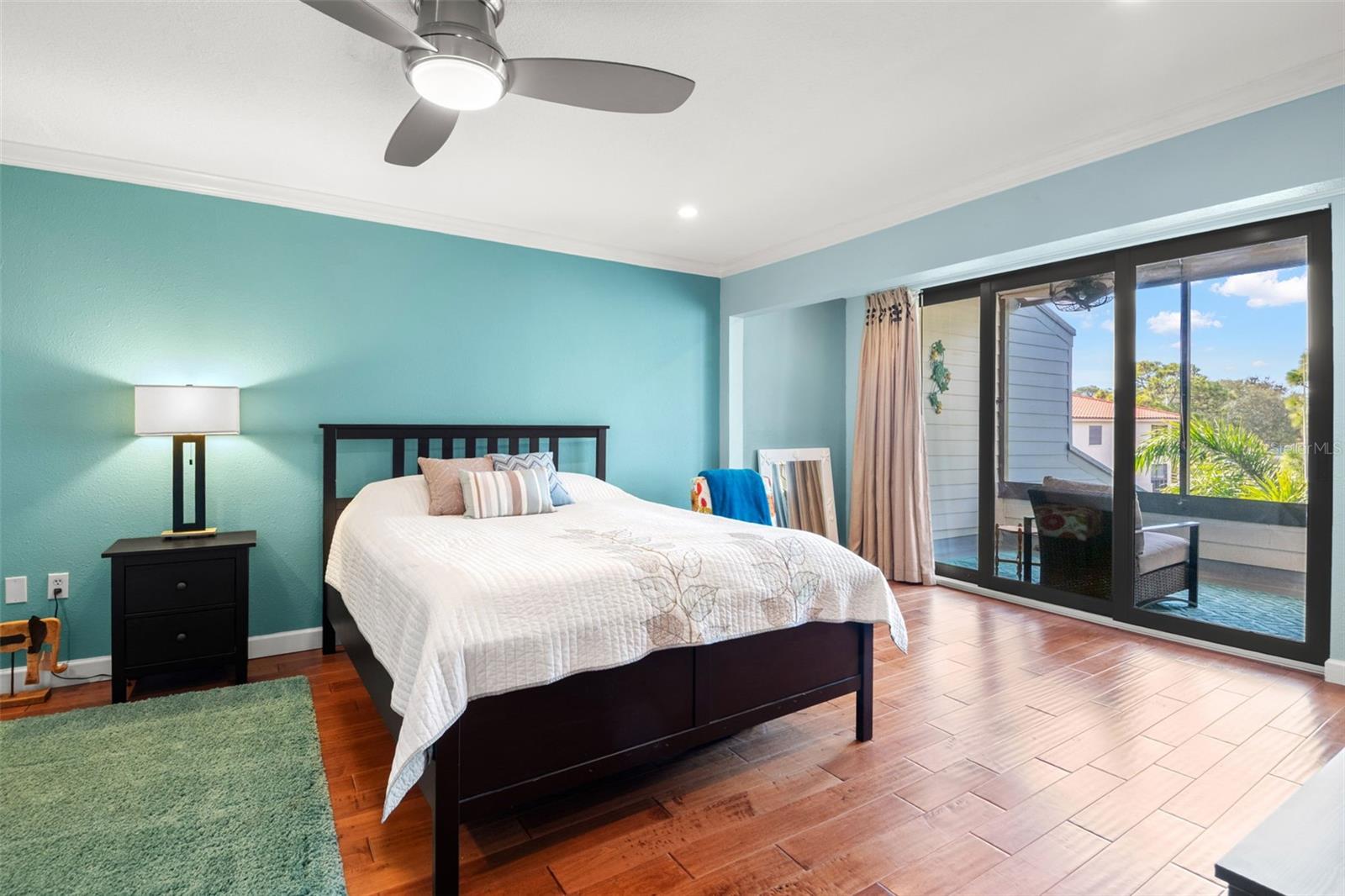 Primary suite with sliding doors to private screen enclosed balcony