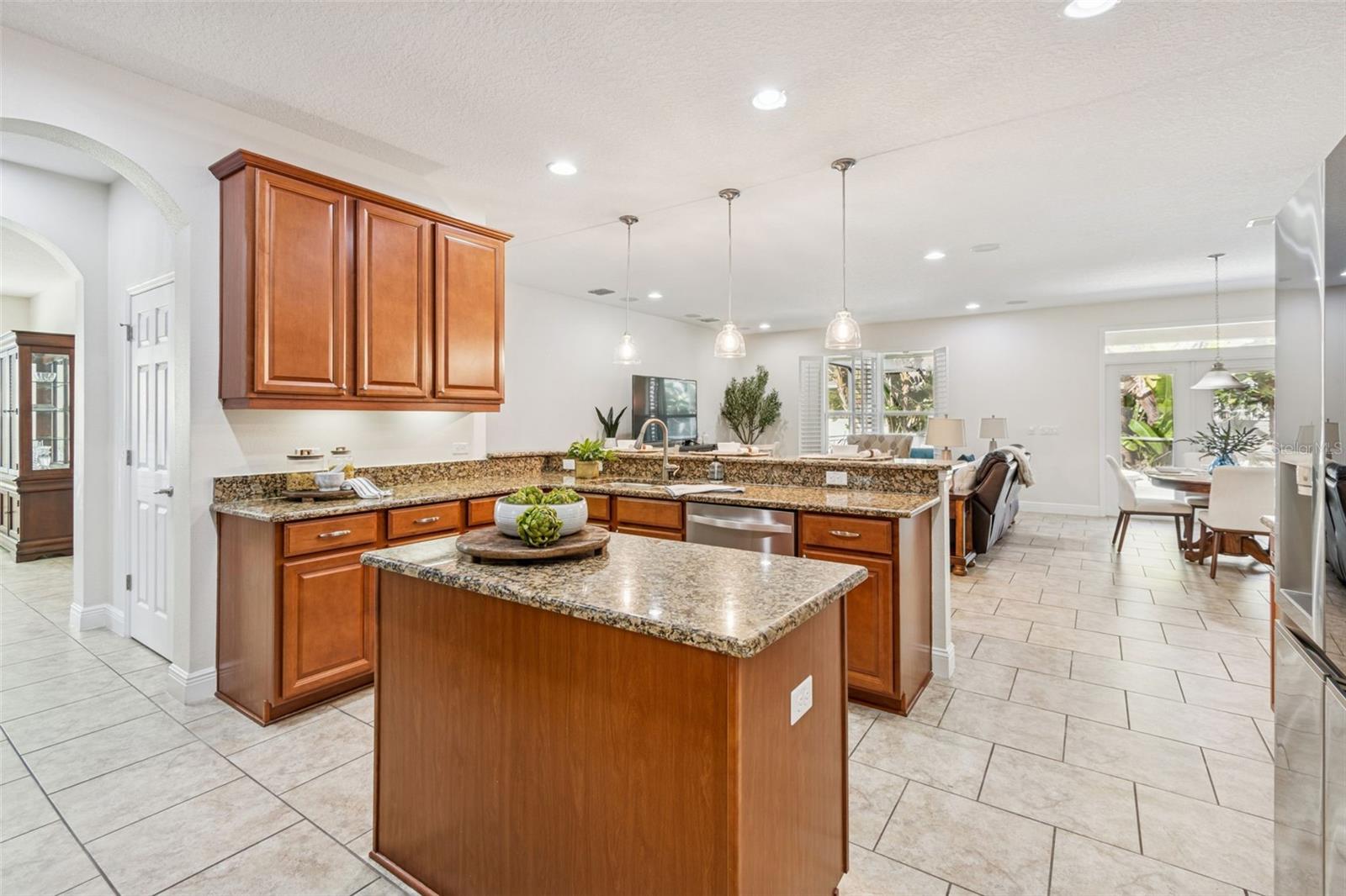 The spacious kitchen centered around a large island, providing ample prep space, additional storage, and a convenient gathering spot for cooking, serving, homework, or casual conversation—making it the true hub of the home.