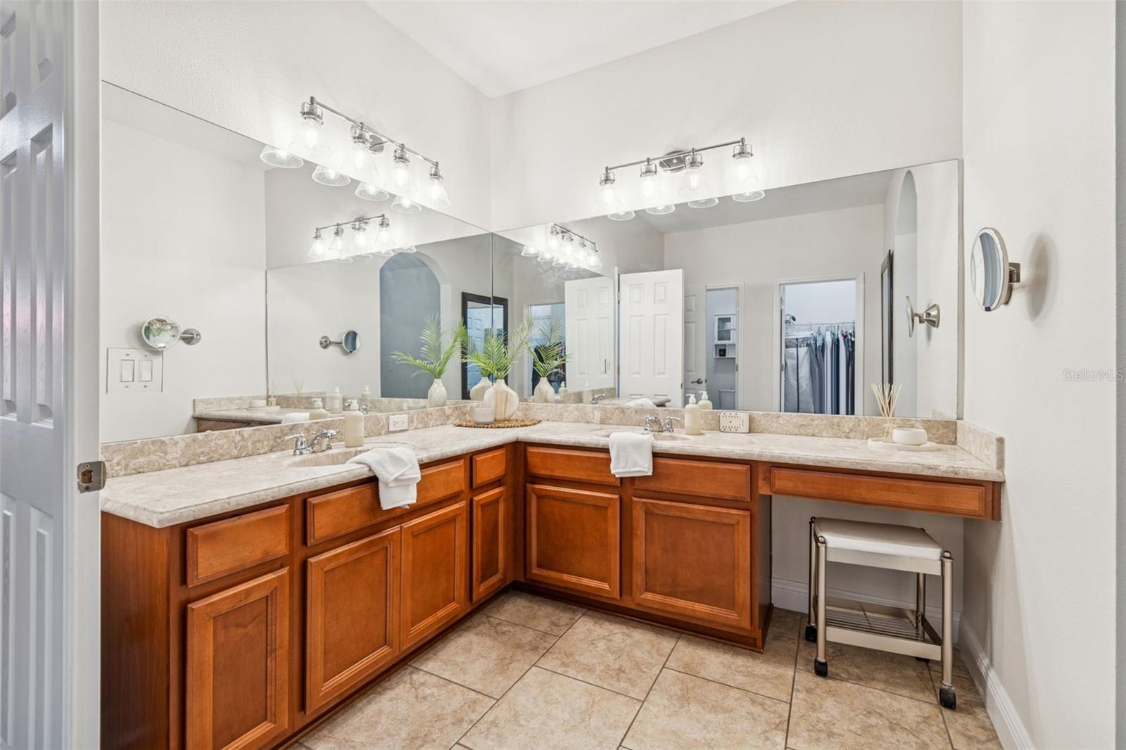 This photo highlights the expansive primary bathroom vanity, featuring dual sinks, abundant cabinetry, oversized mirrors, and bright lighting—creating a spa-like space that’s both elegant and highly functional.