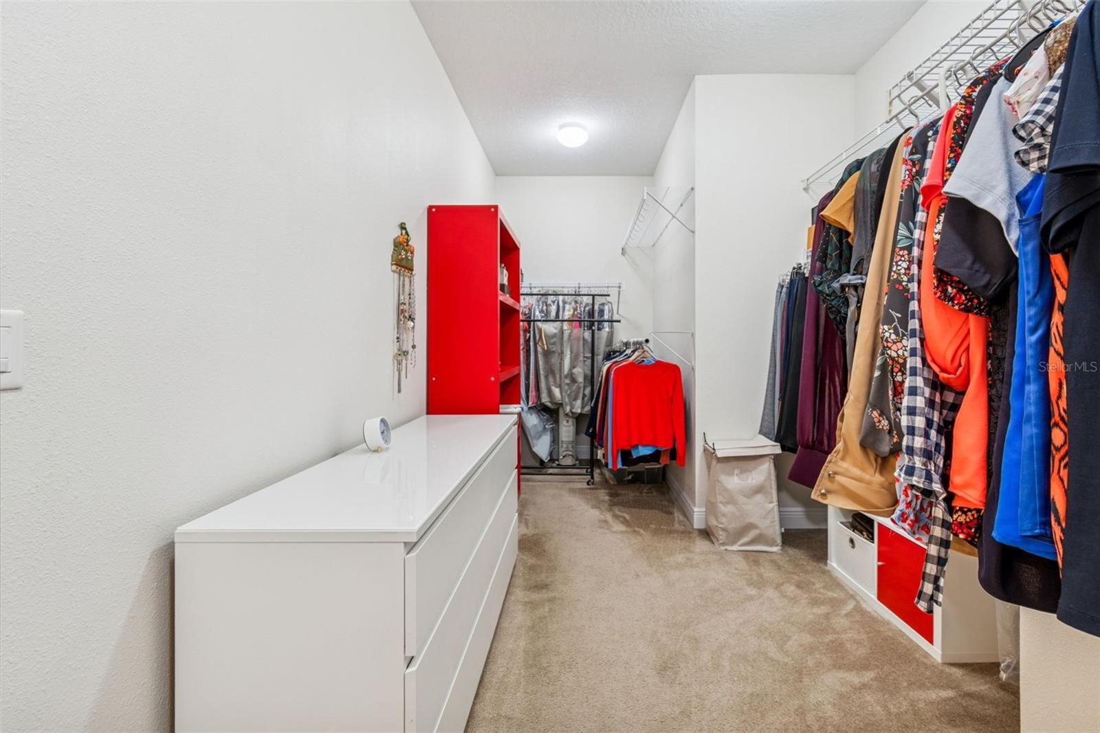 This photo showcases the spacious primary suite walk-in closet, offering generous storage with custom shelving and hanging space—reflective of the large walk-in closets found in each bedroom throughout the home.