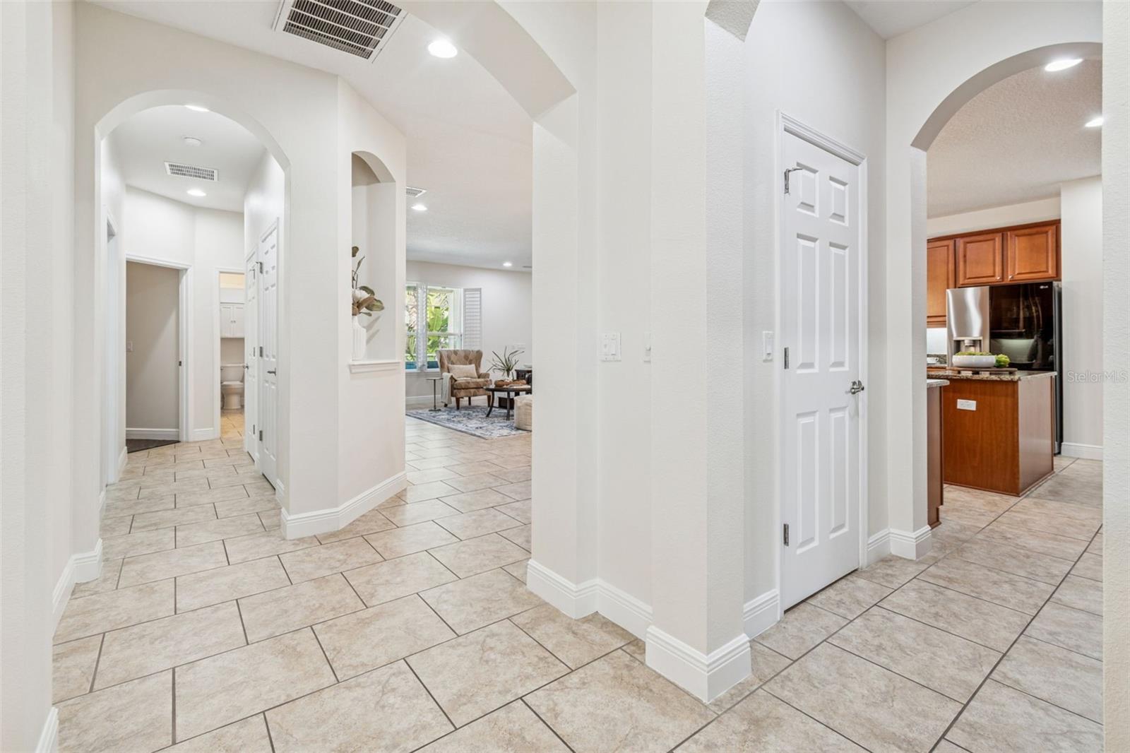 This photo highlights the home’s desirable three-way split floor plan, with the central hallway branching to separate living spaces, bedrooms, and the kitchen—offering privacy, flow, and an open, airy feel.