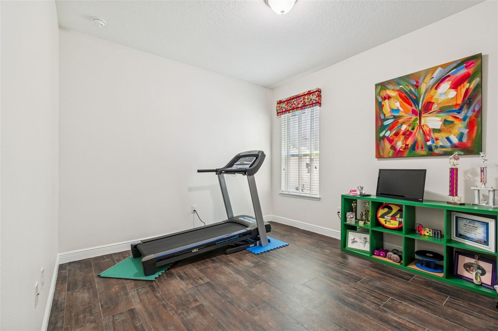 Bedroom 3 is currently being used at an exercise space - newer wood looking tile flooring