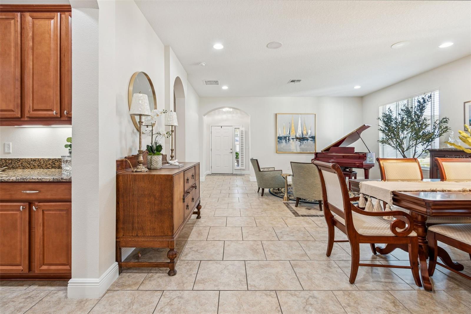 This photo highlights the home’s large open floor plan, where the expansive tiled entry flows seamlessly into the living and dining areas, creating a bright, elegant space that’s perfect for entertaining and everyday living.