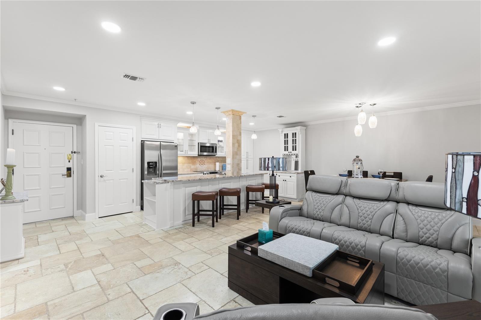View of living room, kitchen and front entrance