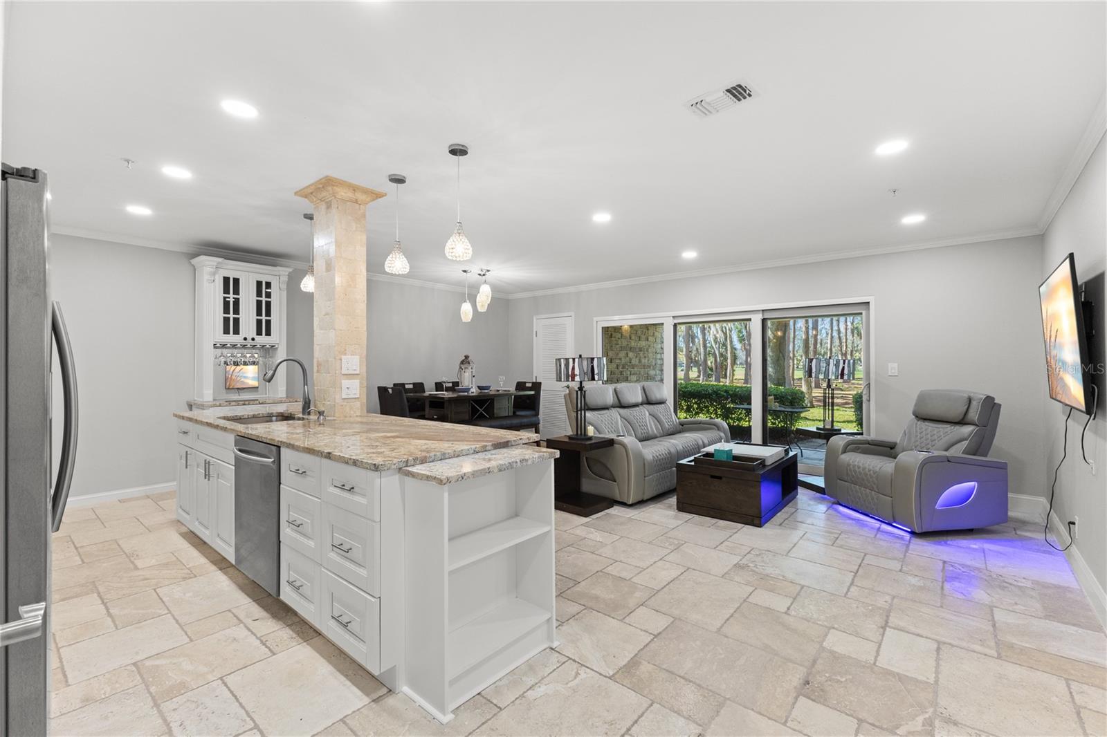 View from front door showing the resealed travertine flooring, open kitchen, dining room and entrance to patio