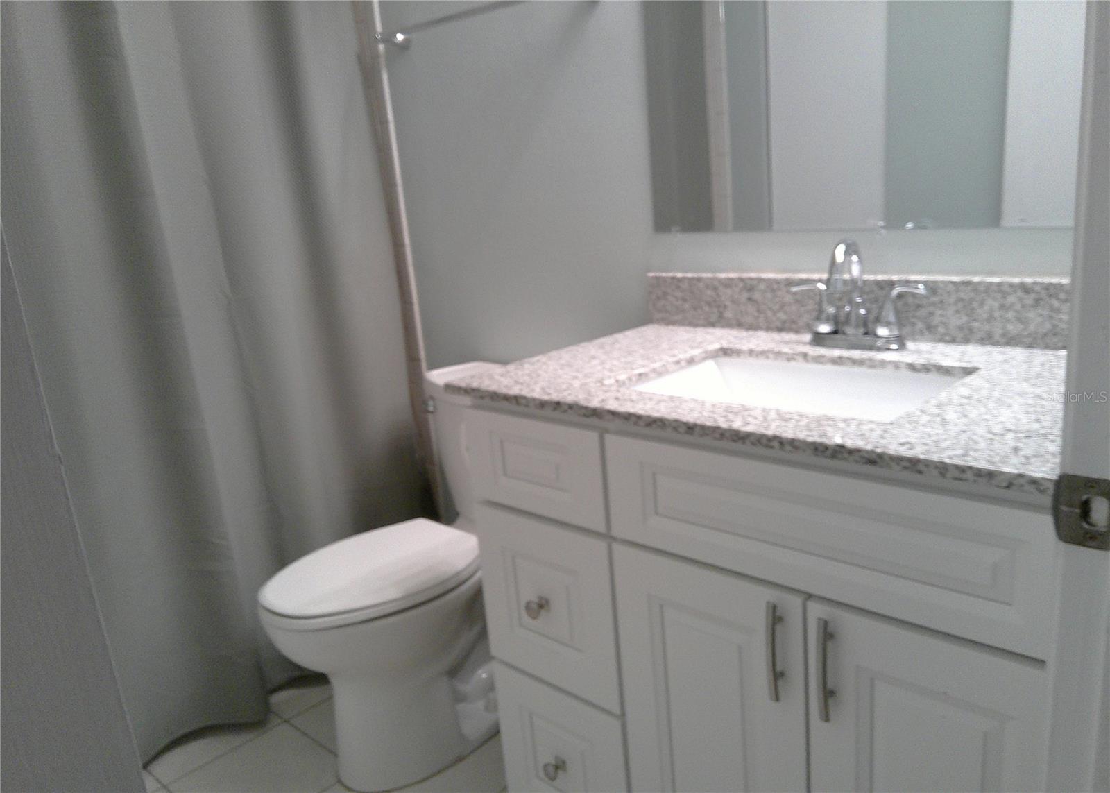 Guest bath offers tub/shower combination.  Updated vanity, easy care tile flooring.