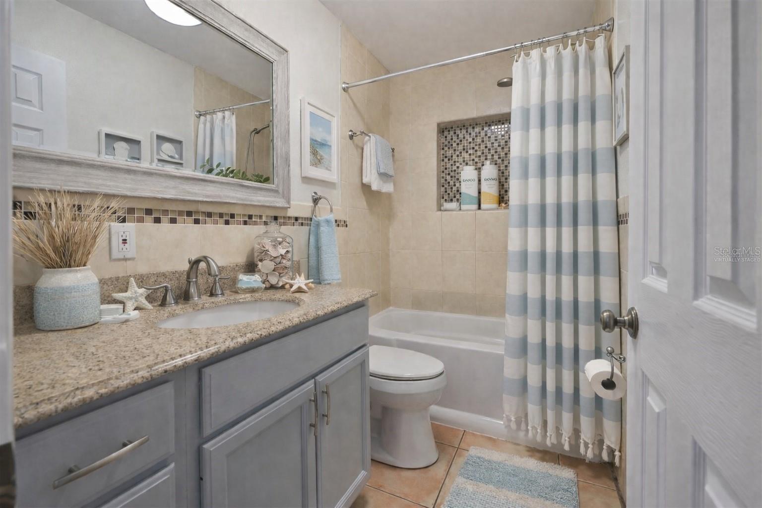 Inviting second bathroom offering a tiled tub/shower & updated vanity.  (Photo has been virtually staged to illustrate the potential use of the space).