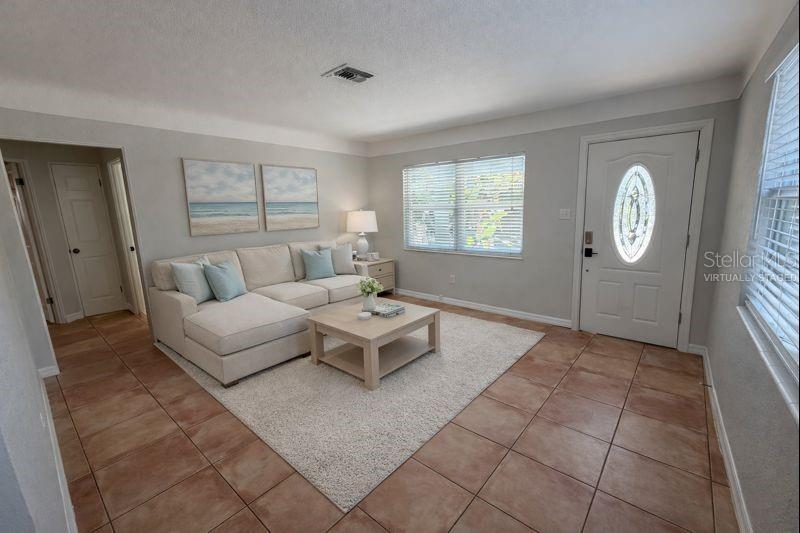 Spacious, sun-filled living room featuring a comfortable flow.  (Photo has been virtually staged to illustrate potential use of space).