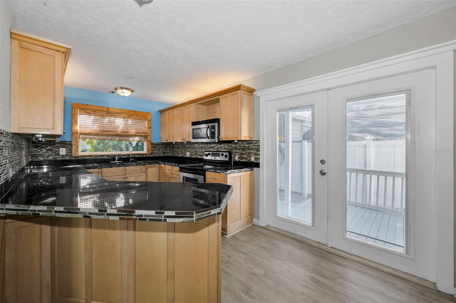 Updated Kitchen with Granite Countertops, tile backsplash & Stainless Steel appliances.
