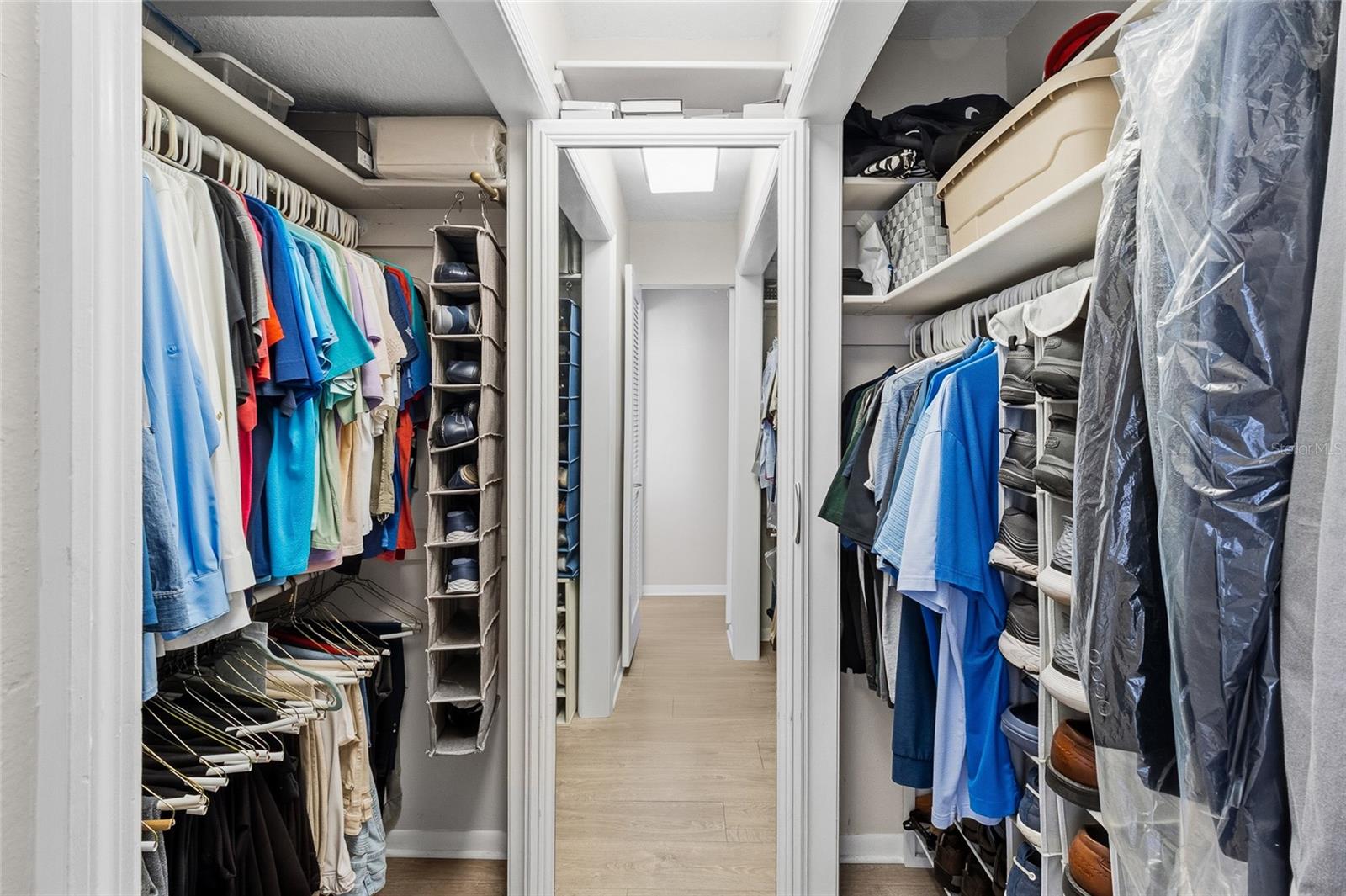 Primary walk in closet. So much storage space.  Mirrored area opens to more storage. See next photo