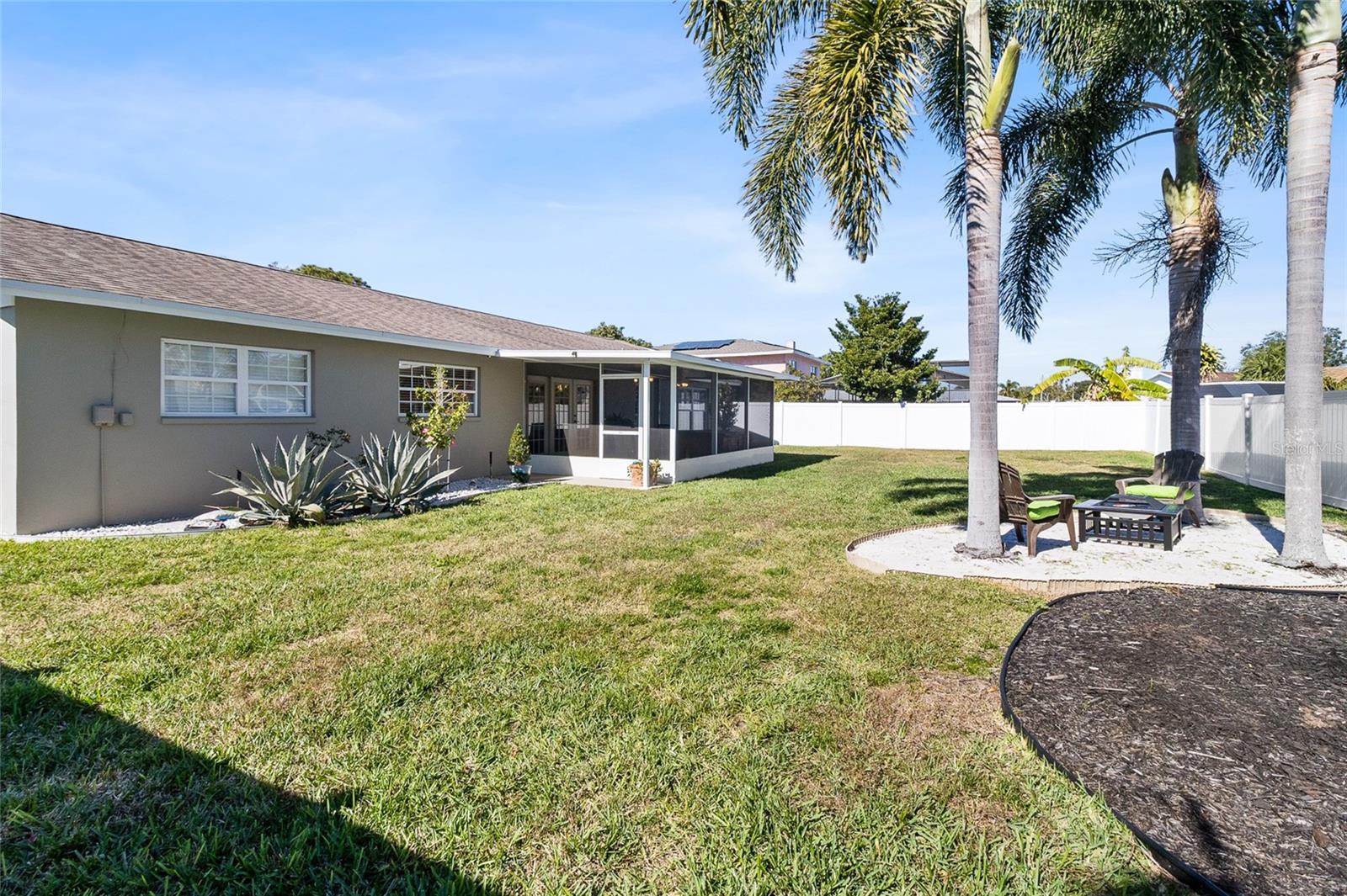 View of back yard.  Personally designed "island oasis" with firepit gives you a Florida coastal vibe.