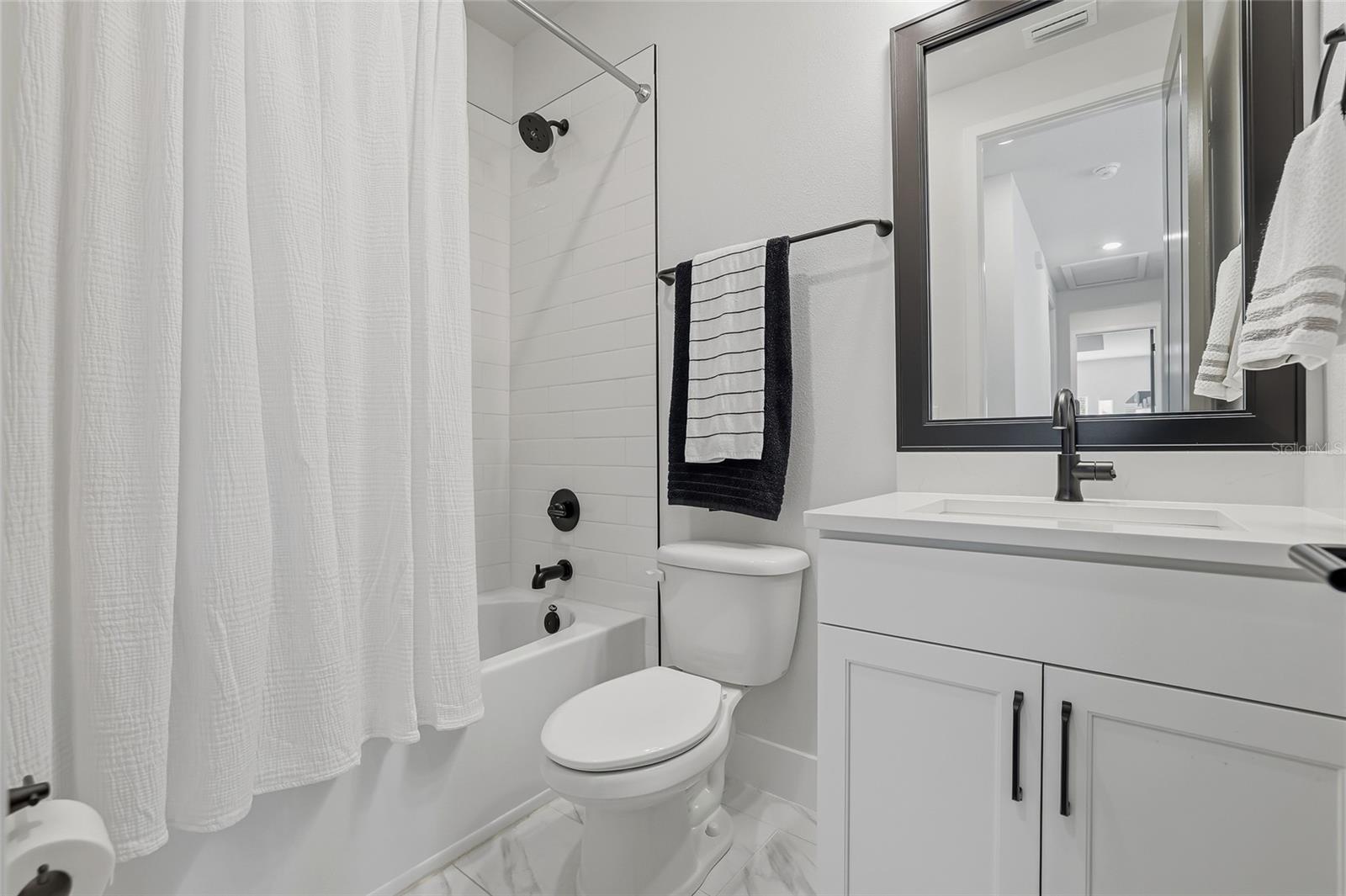 Hall bath with tub serving bedroom 3 and 4.