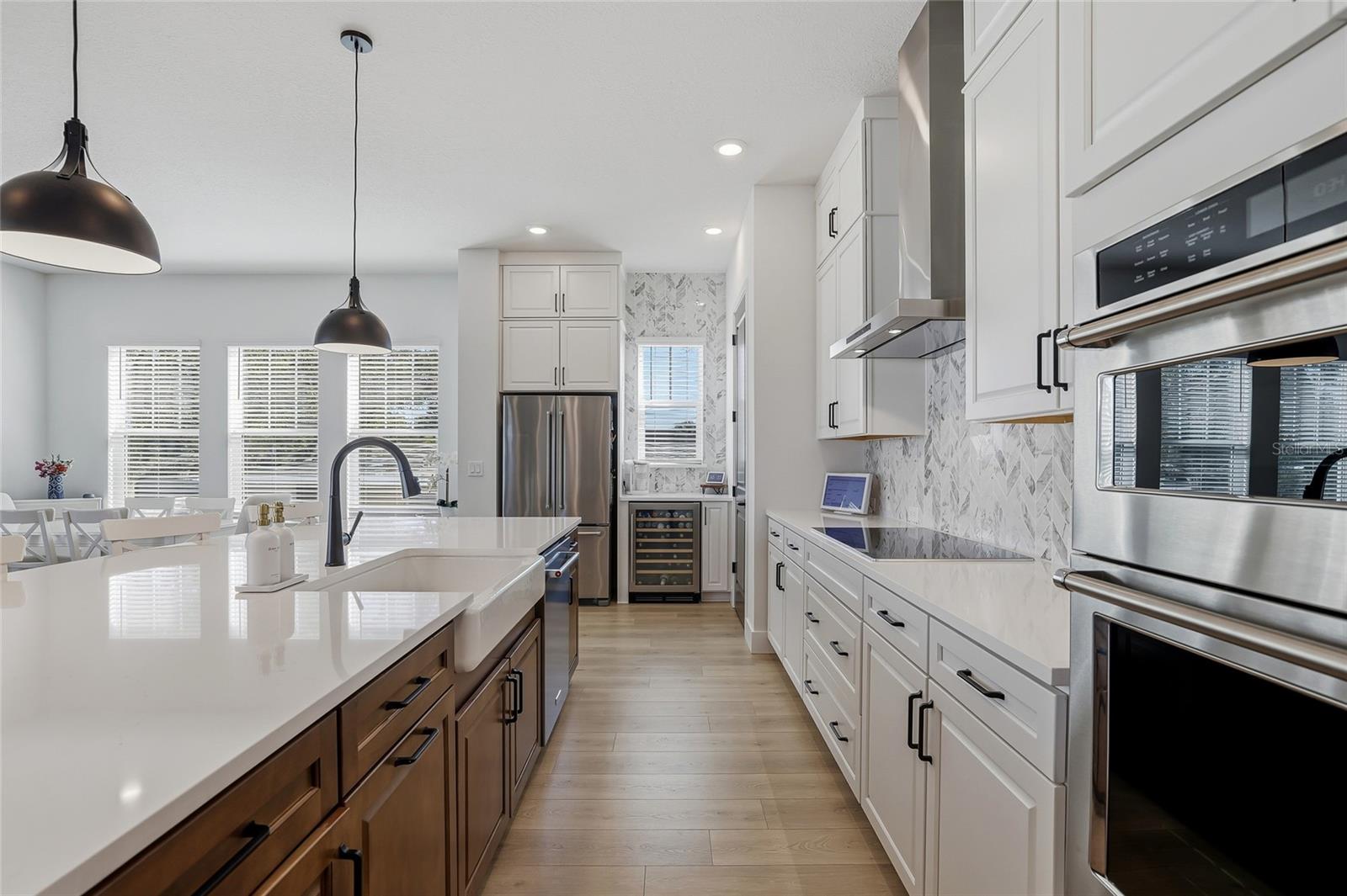 Easy to entertain with the long breakfast bar island, induction cooktop with hood and large pantry.
