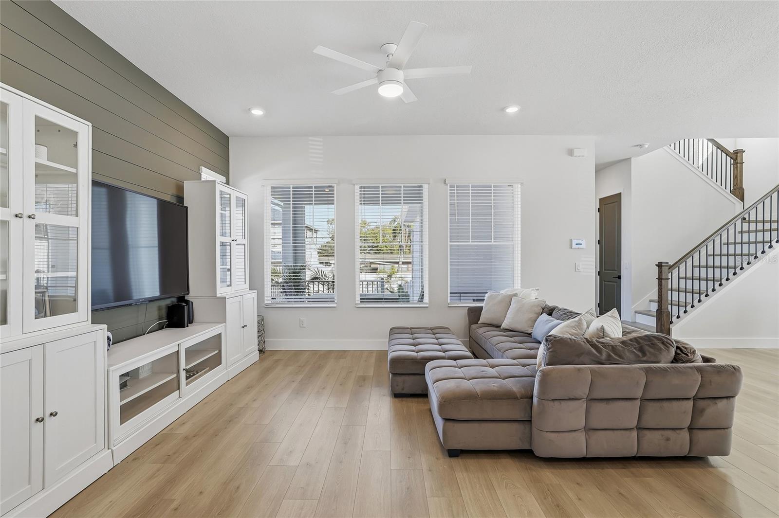 Spacious living room with shiplap accent wall. White cases and credenza do not convey.