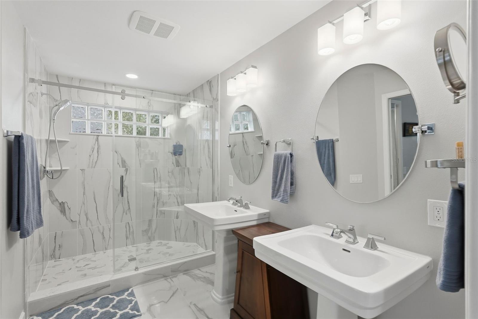 Completely remodeled primary bathroom.  Dual sinks, porcelain tile and custom tile work throughout.