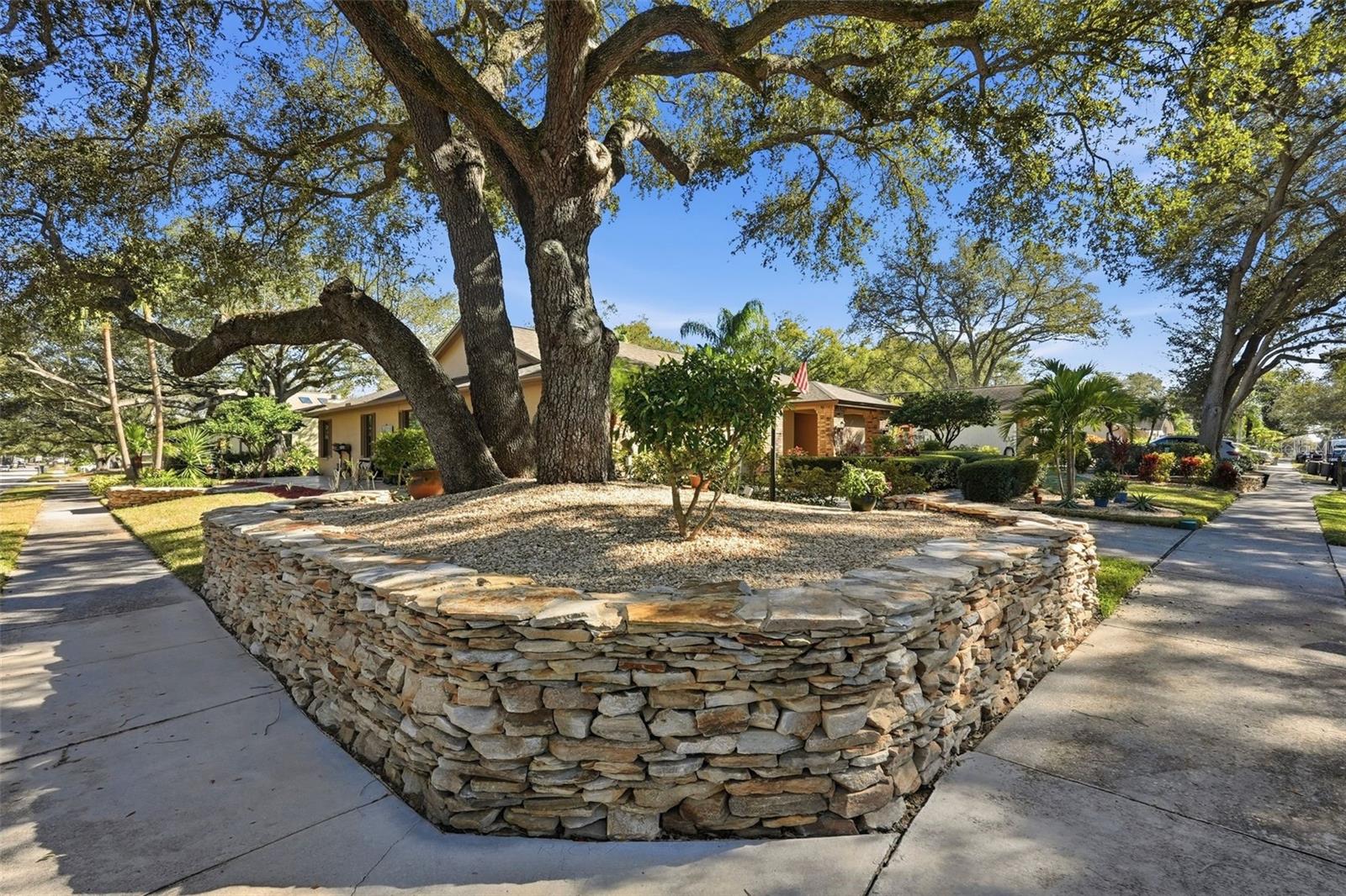 Custom stone wall surrounding the home and landscaping.