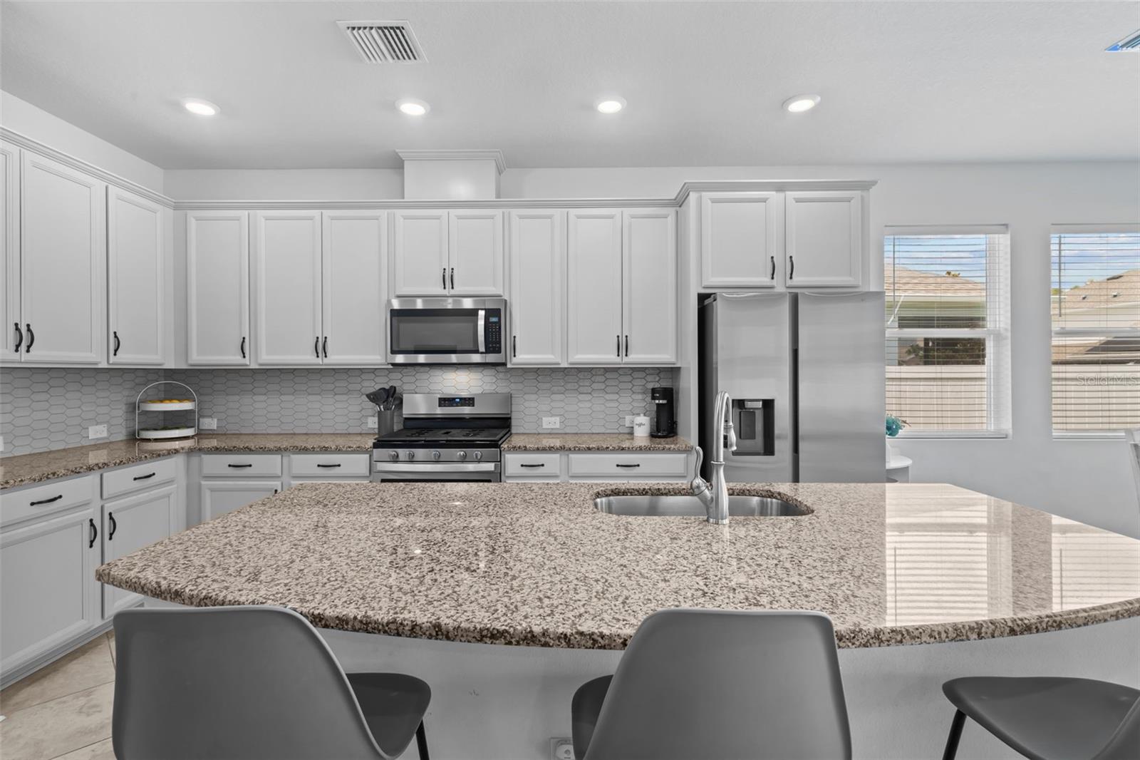 White Kitchen with Gas Range & Granite Island