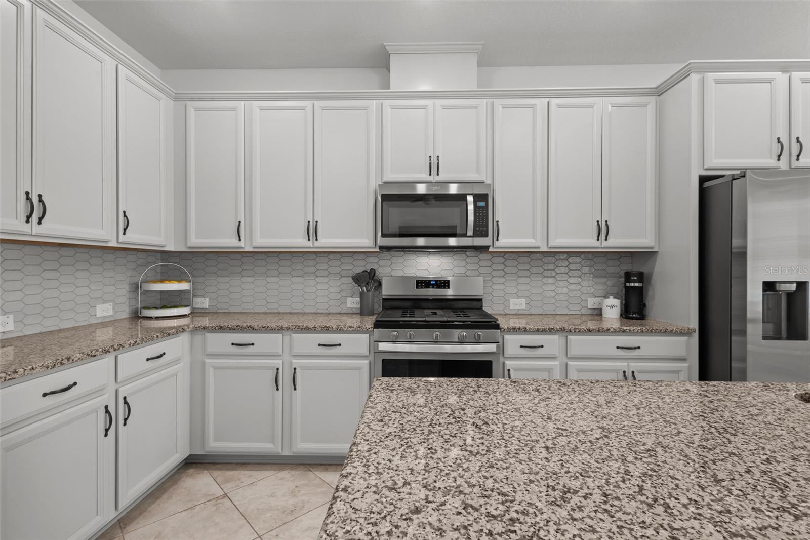 White Kitchen with Gas Range & Granite Island