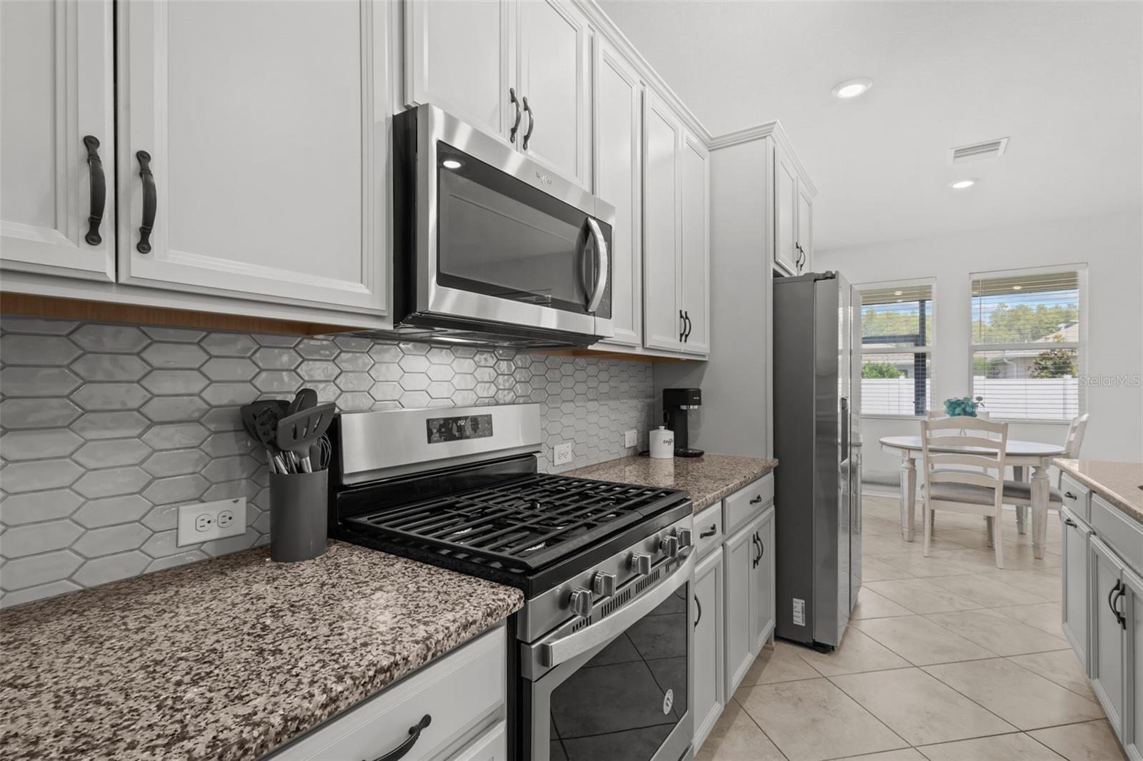 White Kitchen with Gas Range & Granite Island