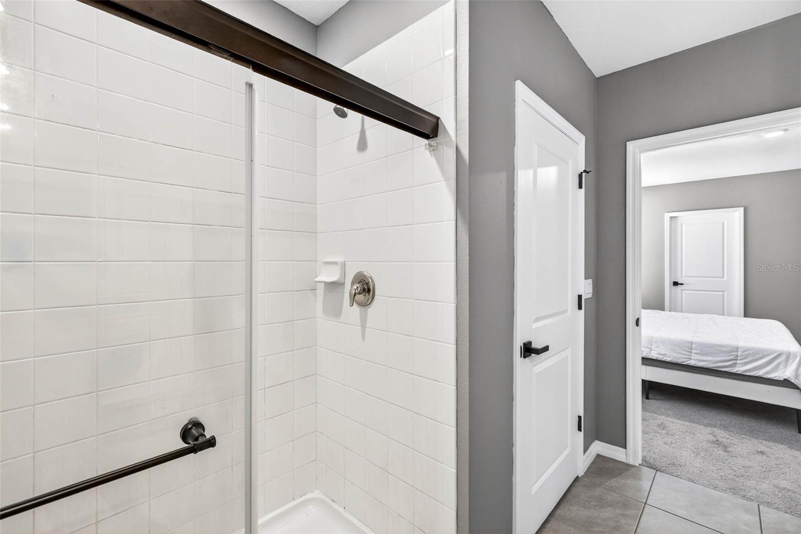 Walk in shower next to linen closet.