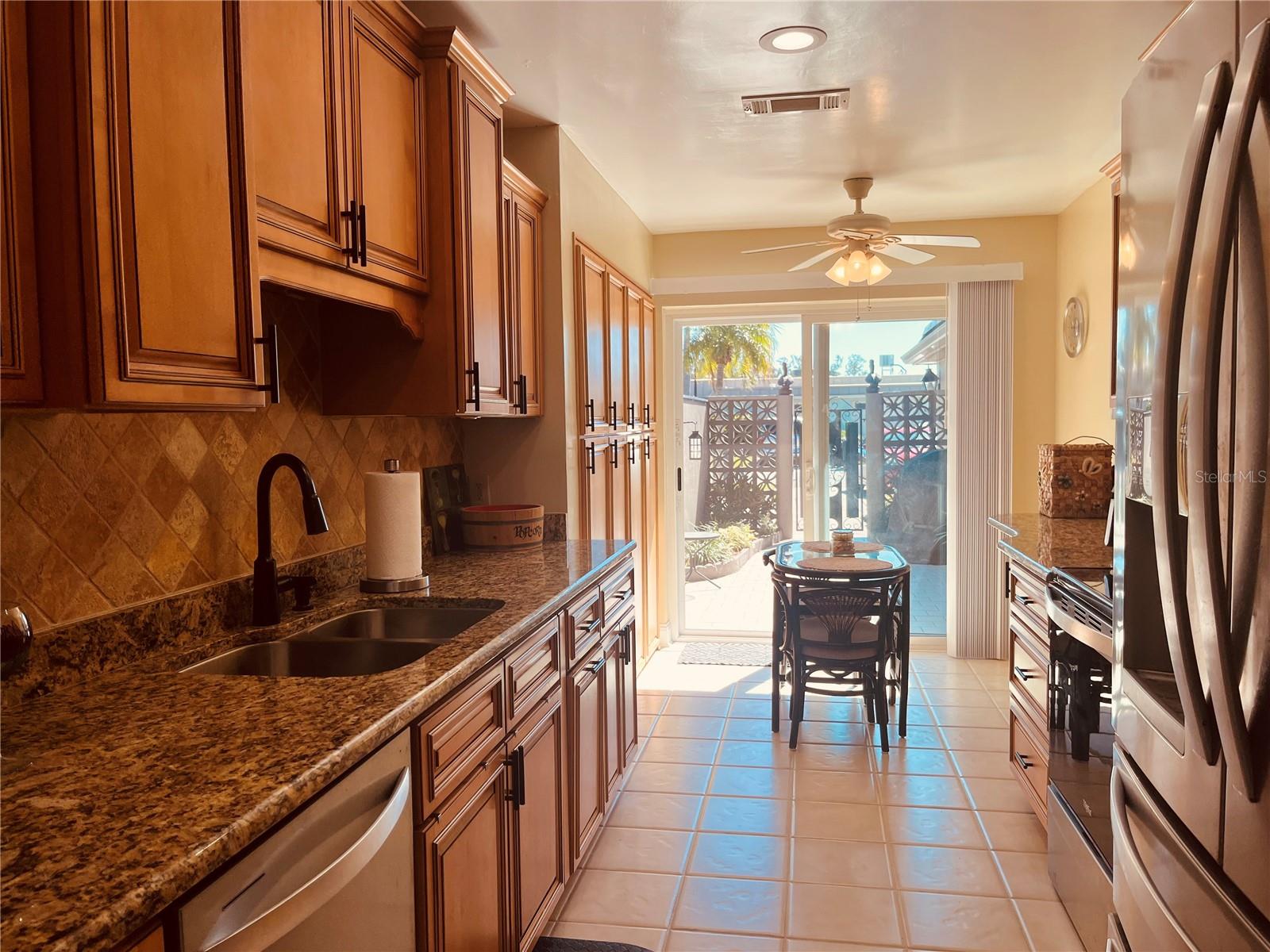 You’re beautifully remodeled kitchen with stainless steel appliances, looking back out through the sliders to the private courtyard entrance!