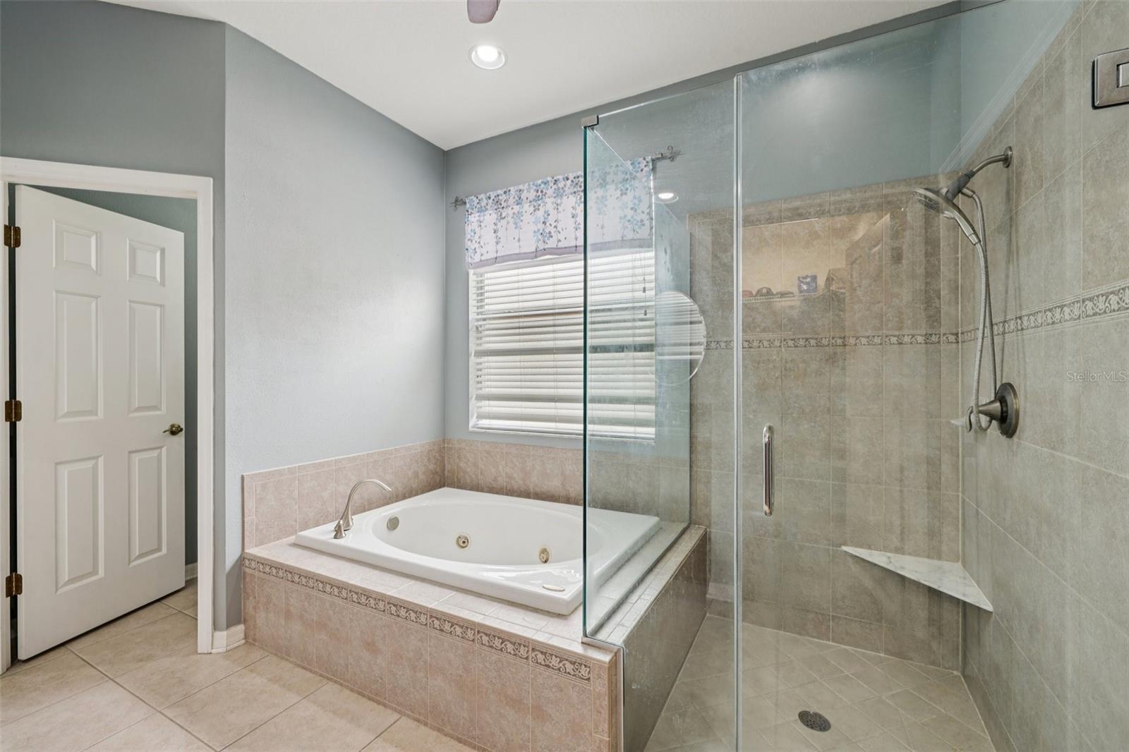 Primary bathroom with large walk in shower and jacuzzi tub and dual vanity