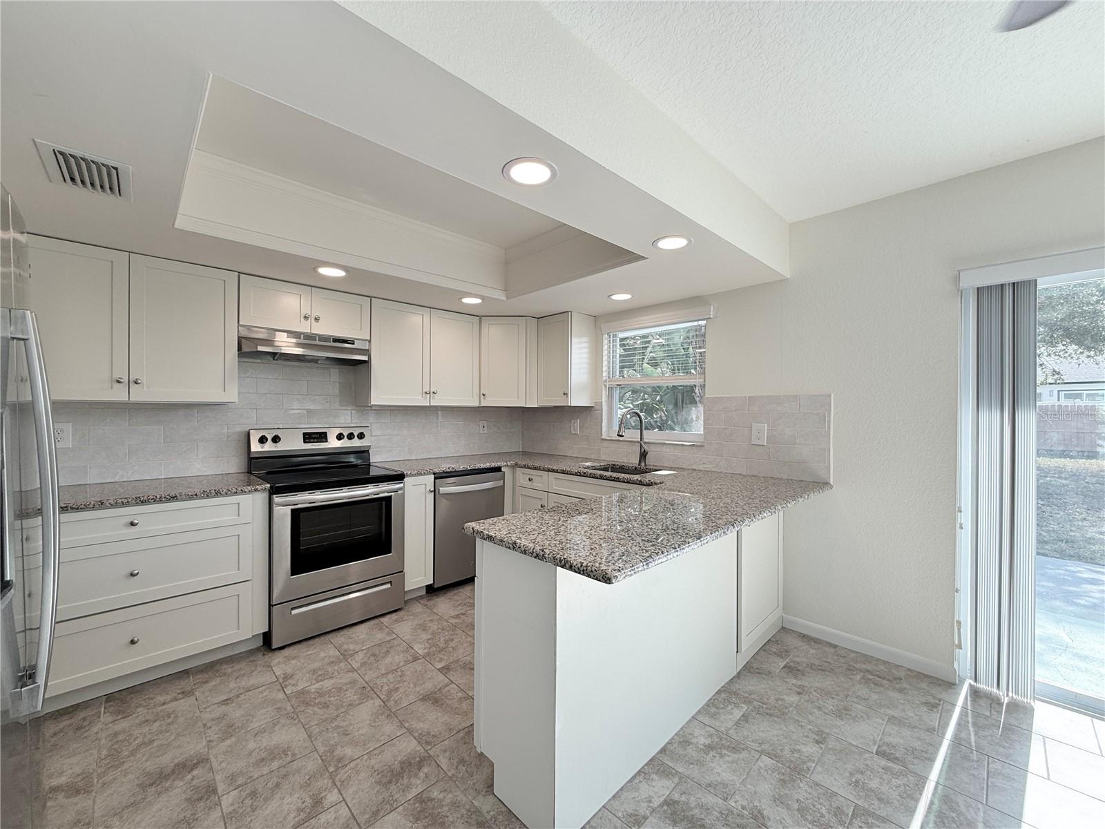 Light and bright kitchen with all soft-close cabinets, large five drawer pantry, all stainless steel appliances and granite counters.