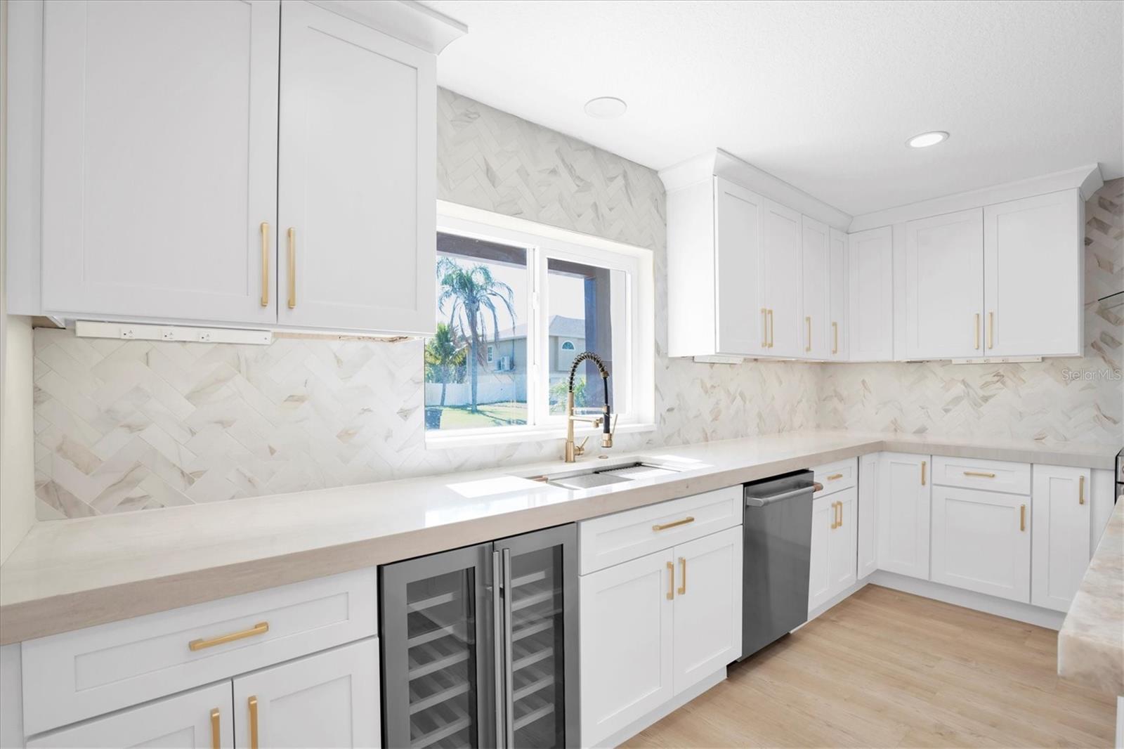 With quartz counters, a glamorous tiled backsplash & a sleek wine chiller, this exquisite kitchen elevates every culinary & entertaining experience.